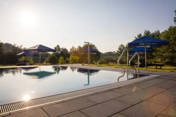 A swimming pool with blue parasols.