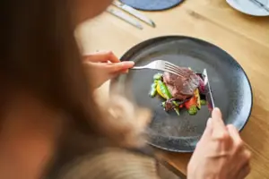 A person is eating food from a plate.