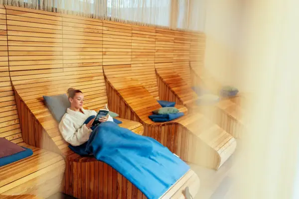 A woman is sitting on a wooden chair.