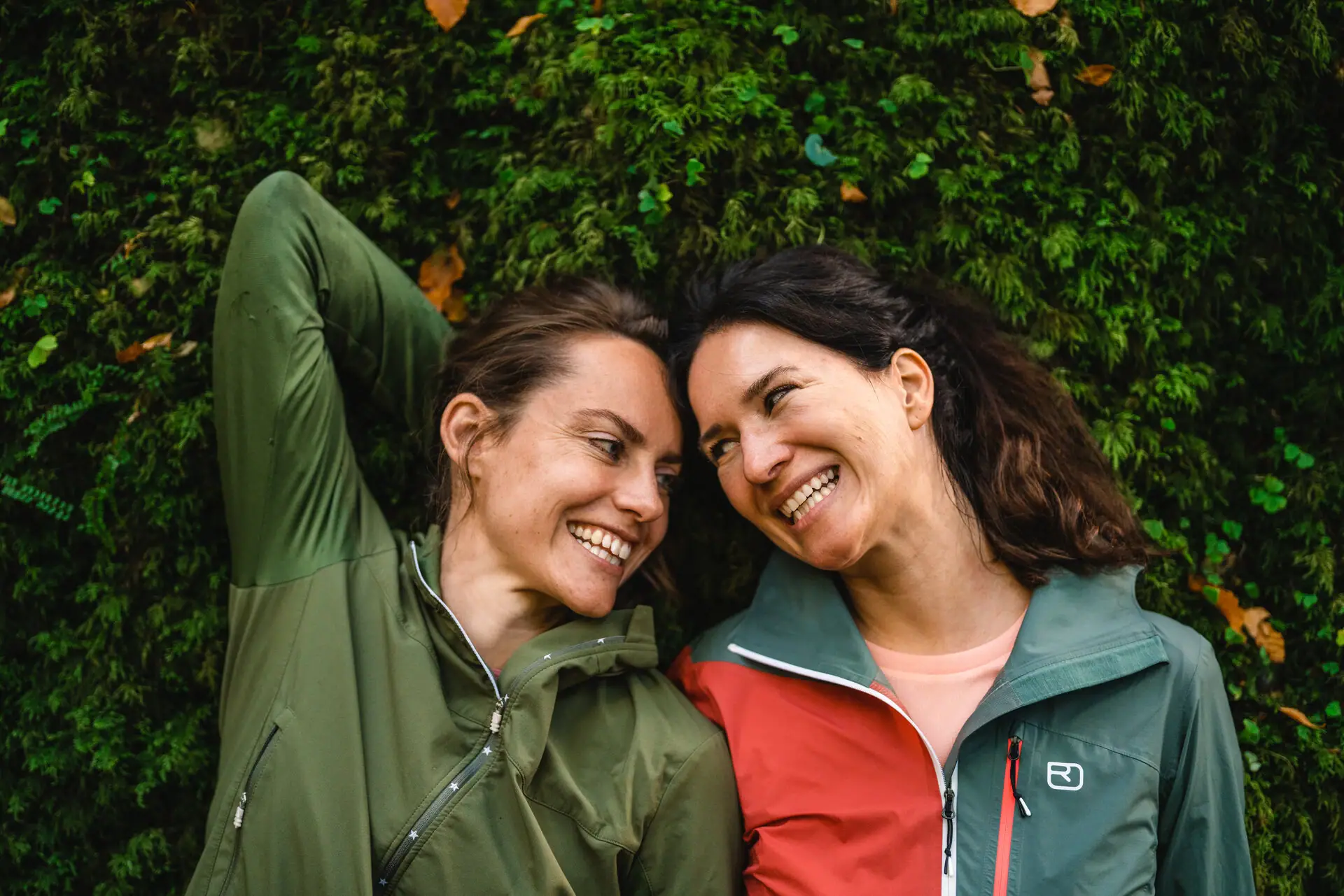 Two women smile at each other.