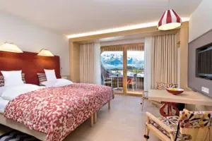 A room with a bed, a table and chairs.