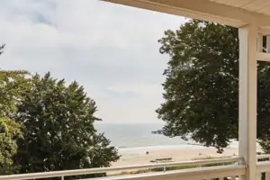 A terrace with chairs and a table on it.