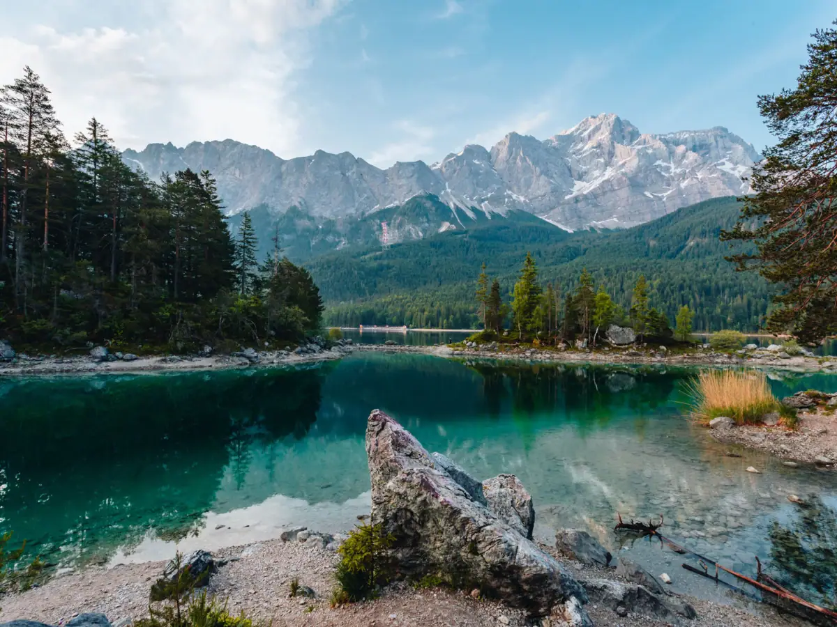 The Eibsee A lake with trees and mountains in the background.