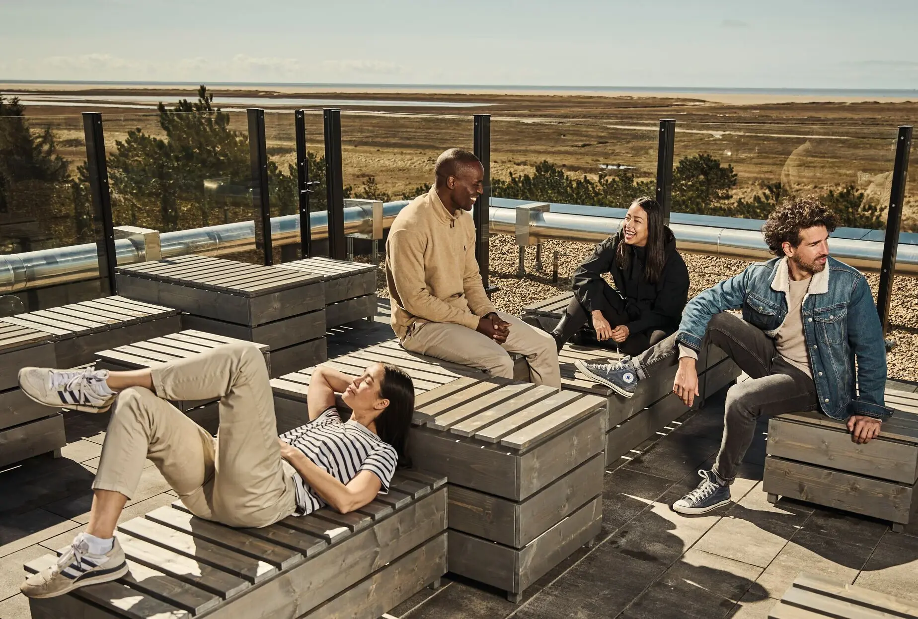 A group of people are sitting on a wooden bench.