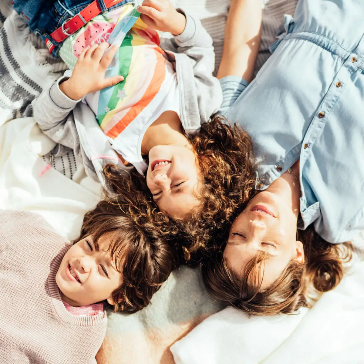 A group of people are lying on a blanket.