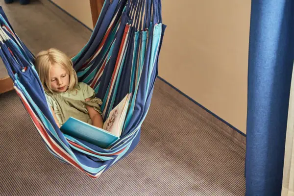 Girl reading a book in a hammock.