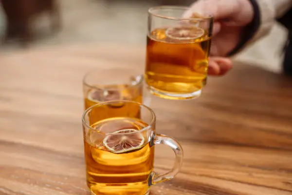 Hand holds a glass of alcoholic drink.