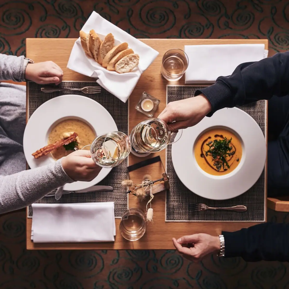 Dinner Two people sitting at a table with plates and wine glasses.