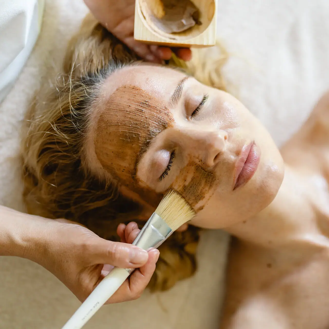 SPA application A woman lies with a brown mask on her face.
