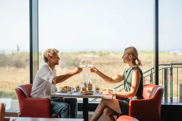 Abendessen Ein Mann und eine Frau sitzen an einem Tisch mit Weingläsern.