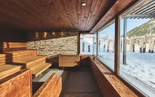 Sauna with wooden benches and large windows.