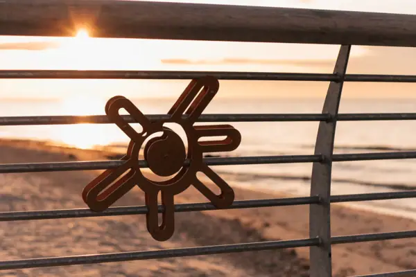 Metal railing with a sun symbol on it.