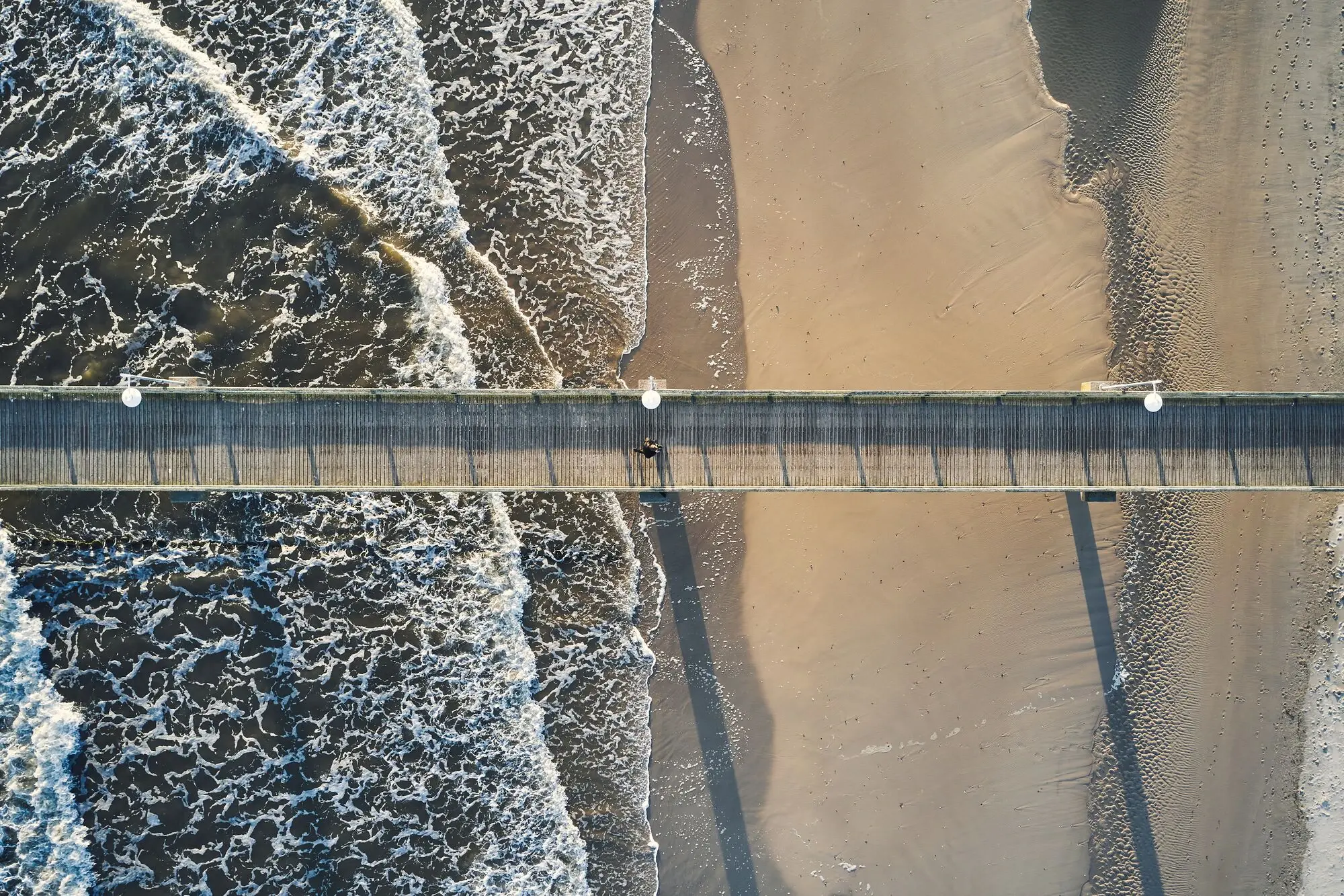 A pier over the sea and the beach.