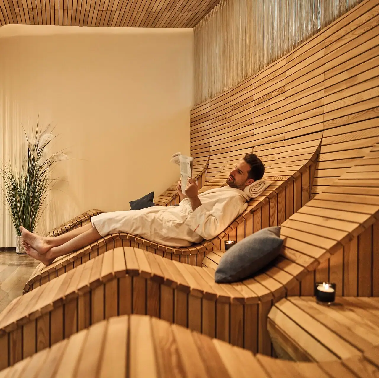 A man and a woman in a relaxation room with wooden benches.