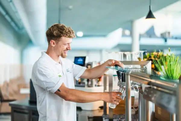 A man pours water from a tap.