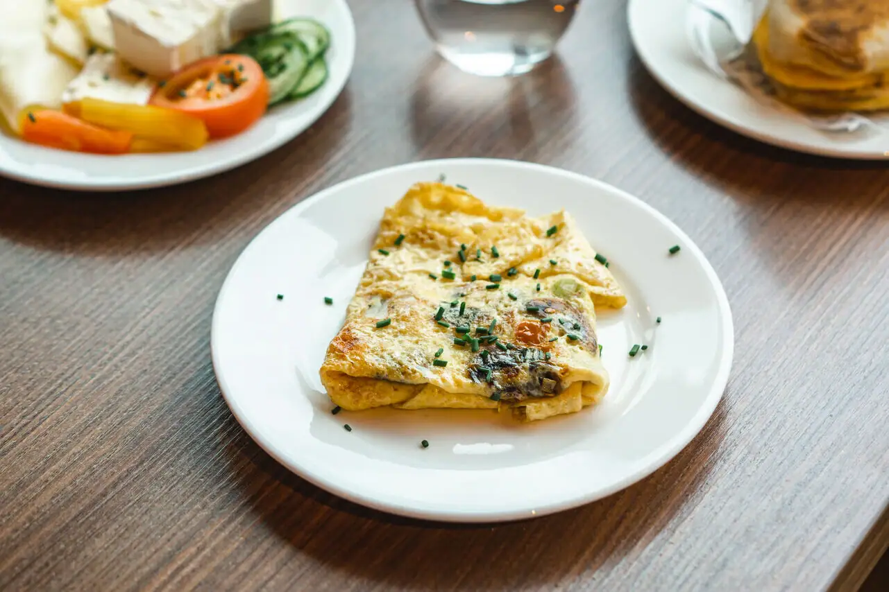 A table with plates full of food and drinks.
