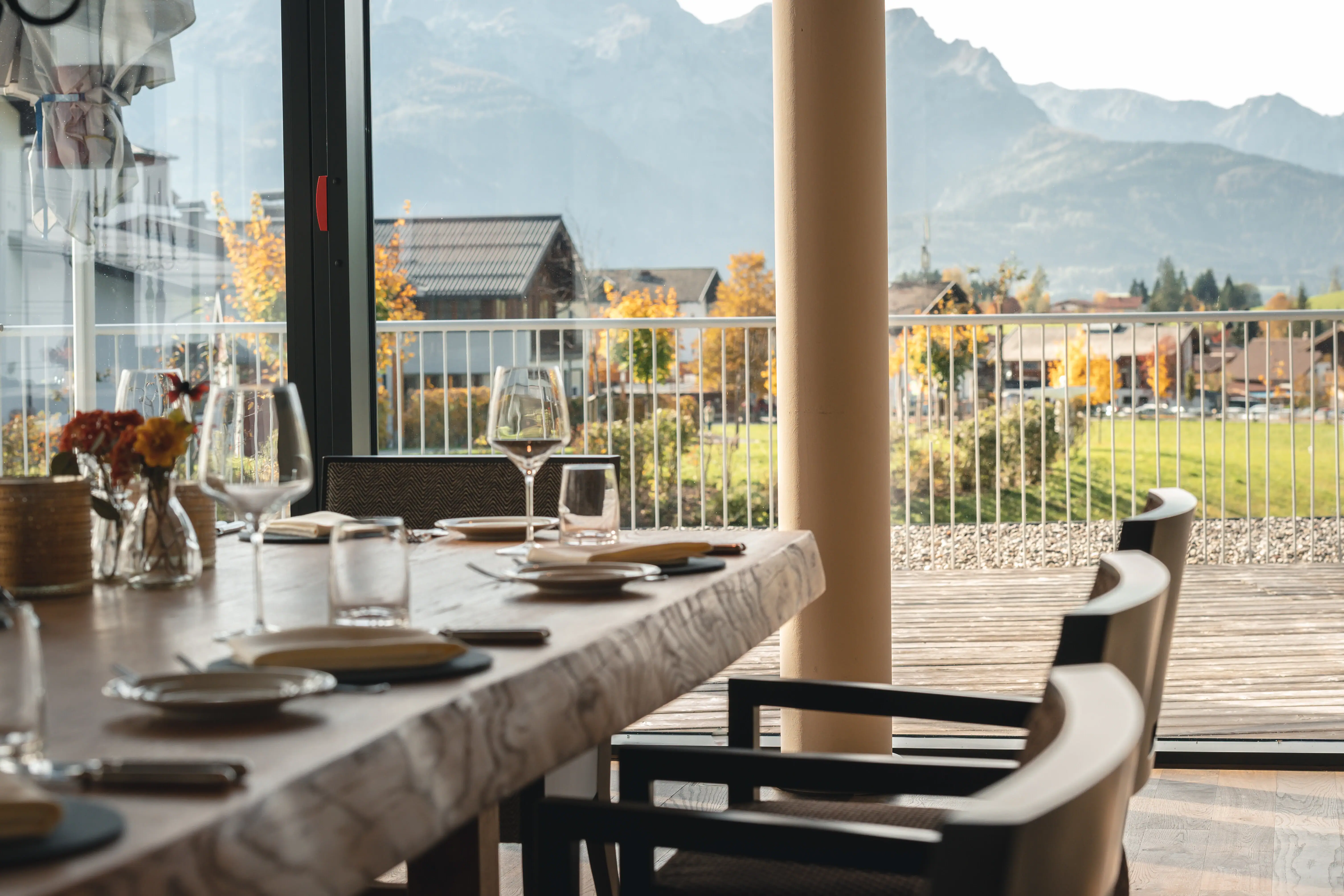 Fine point A table with plates and glasses on it, in an outdoor area.