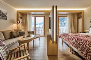 Junior suite A room with a bed, a table and chairs.