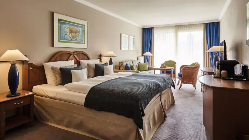 Hotel room with bed and chairs, elegantly furnished and decorated.