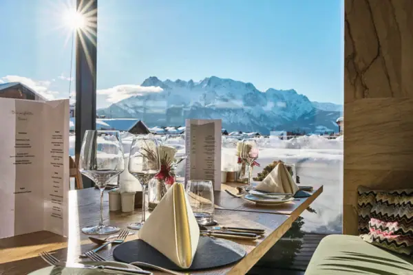 A table with glasses and napkins, a mountain in the background.