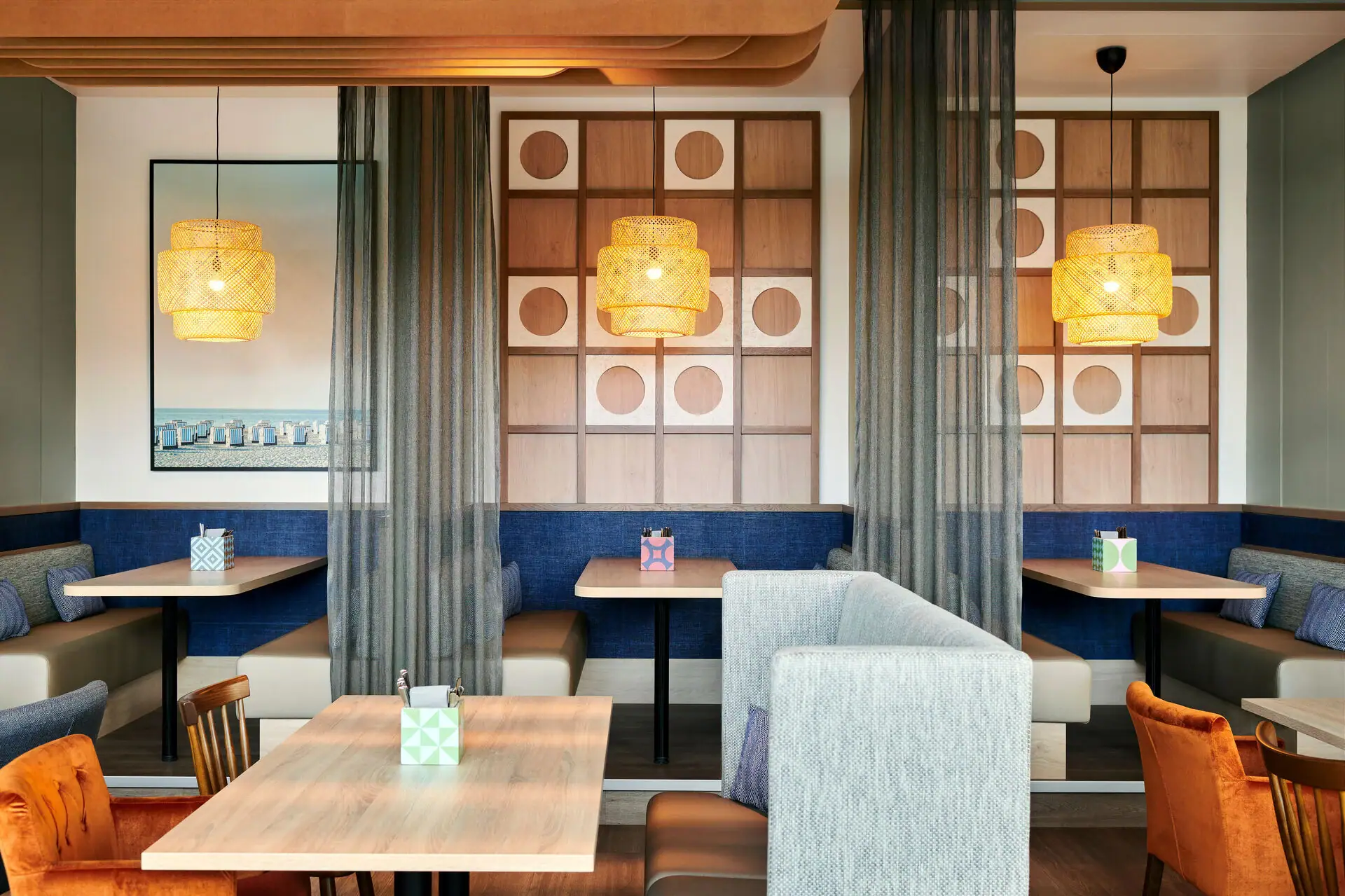 A room with tables and chairs and individual bunks, separate areas.