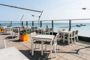 Ein Tisch und Stühle auf einer Terrasse.