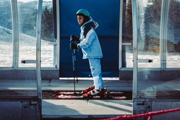 Child on skis outdoors, wearing winter clothing.