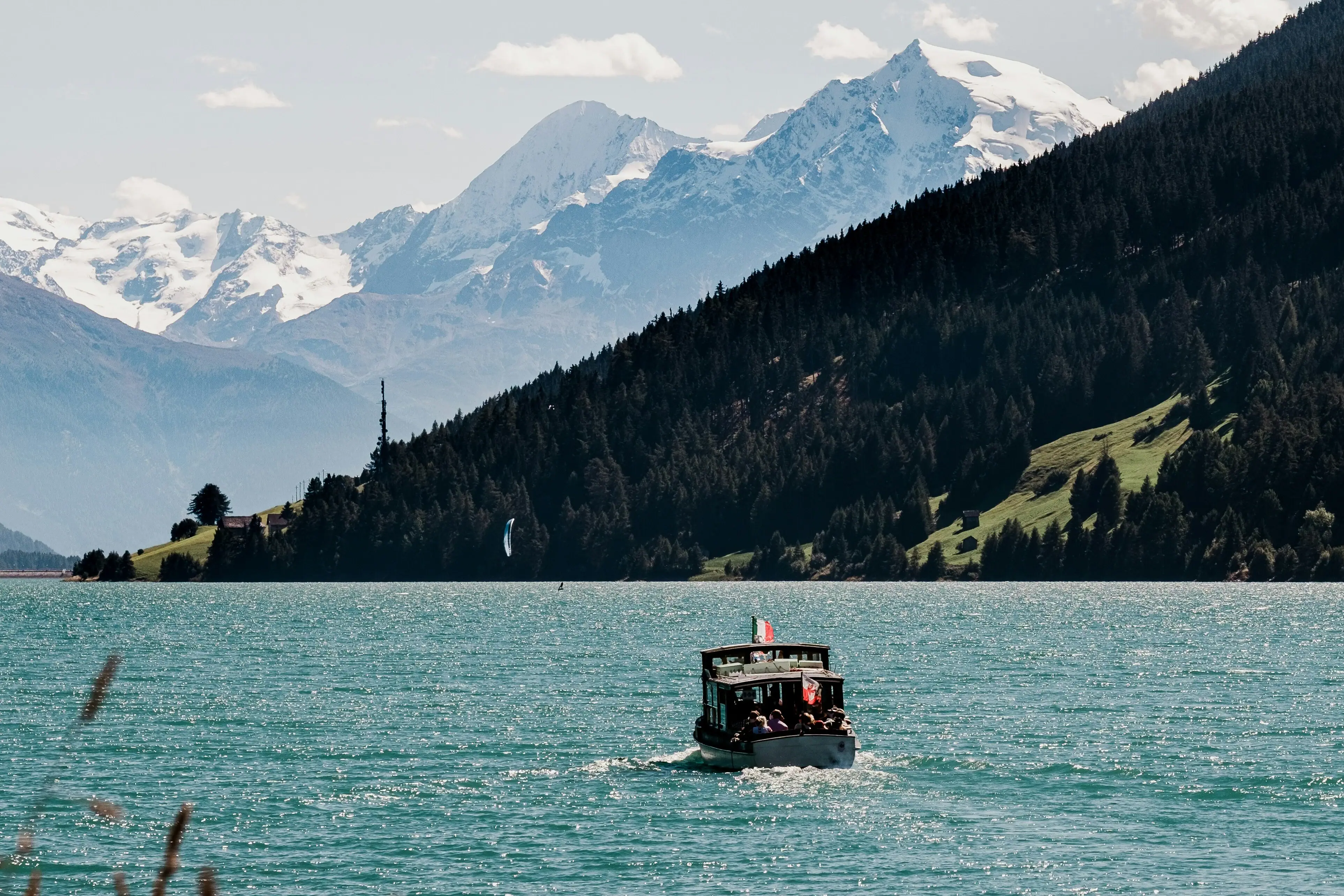 Boat trip A boat in the water with mountains in the background.
