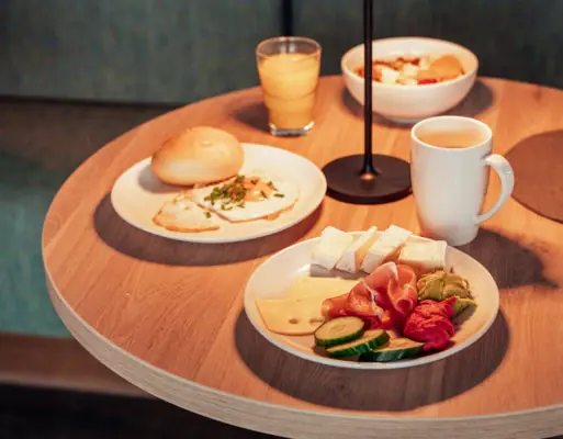 A table set with plates of food and a lamp.