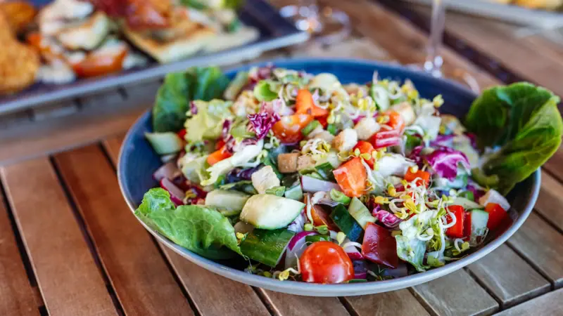 A plate of fresh salad on a table.