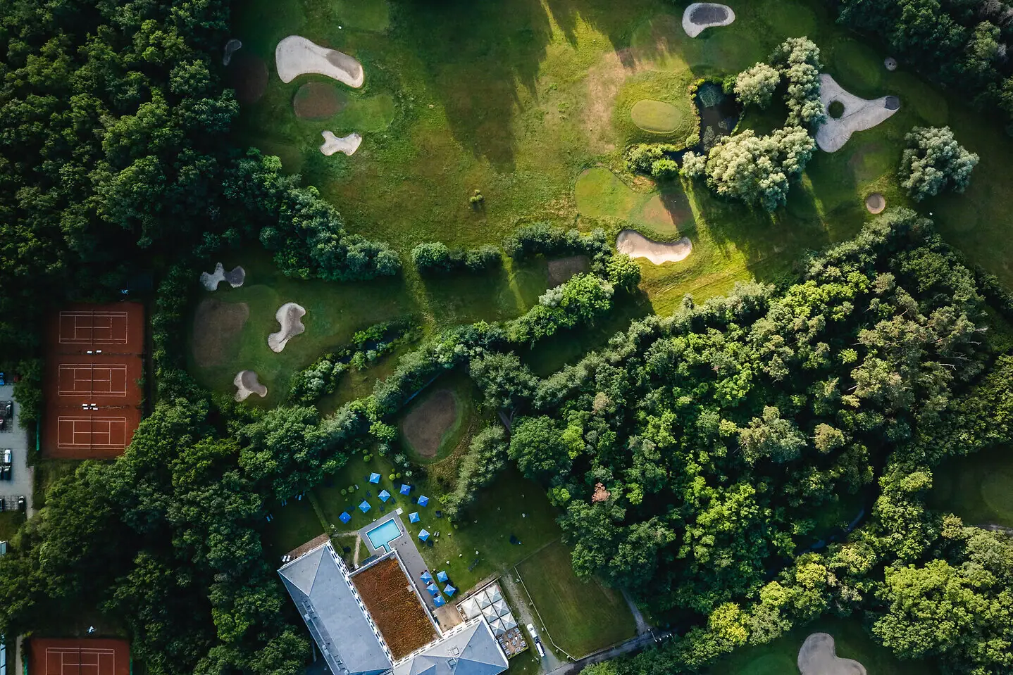 Golf in Bad Saarow Aerial view of a golf course with trees and a water hazard.