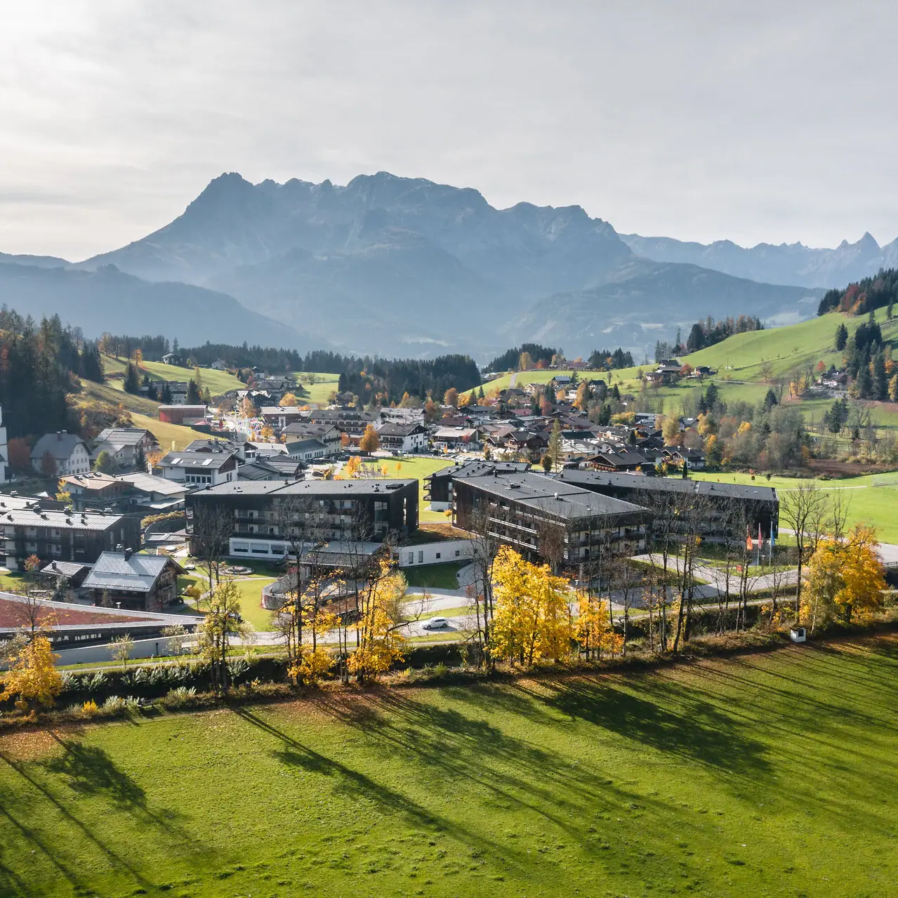 City in a valley with mountains in the background and a slightly cloudy sky.