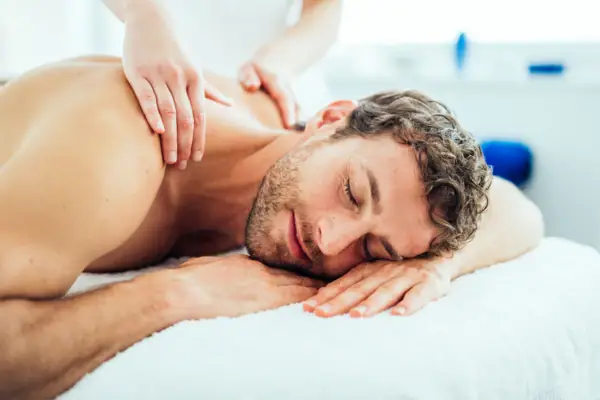 A man is lying relaxed on a massage table.