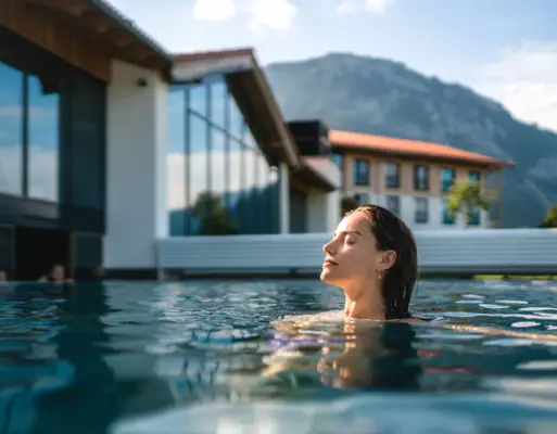 Outdoor pool at aja Ruhpolding A woman with her eyes closed in the pool.