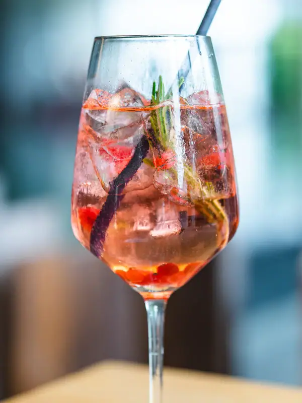 A glass with a drink and a straw.