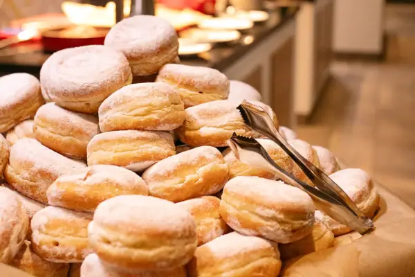 A stack of pancakes with icing sugar.