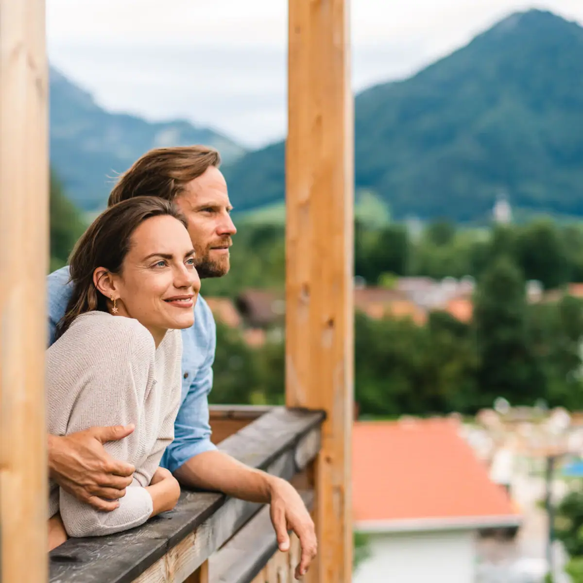 A man and a woman lean against a railing.