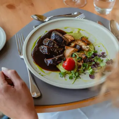 Plate of food on a tray with tableware.