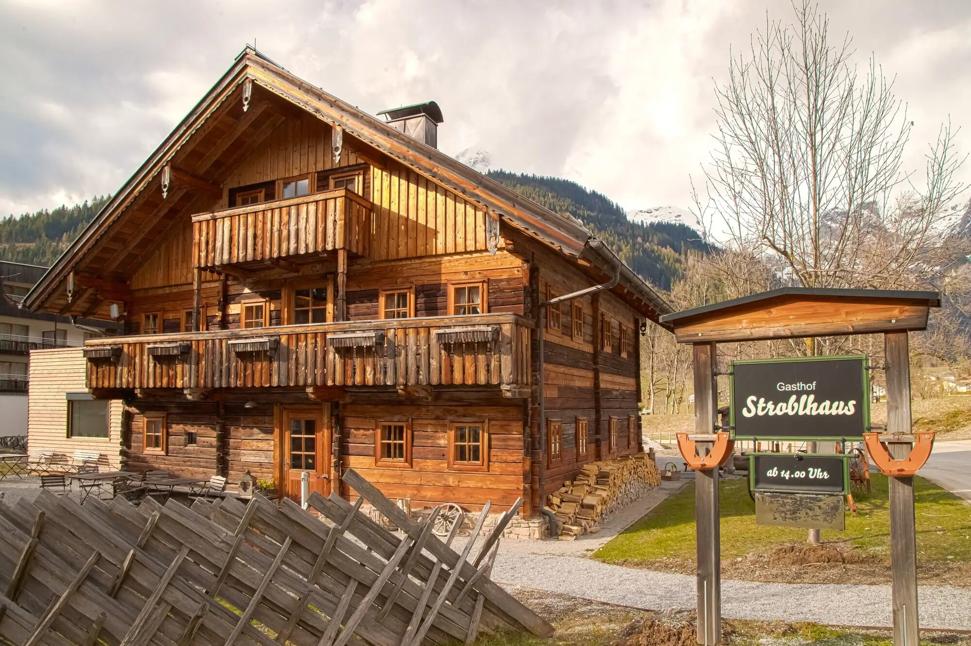 Stroblhaus Werfenweng A wooden house with a sign in front of it.