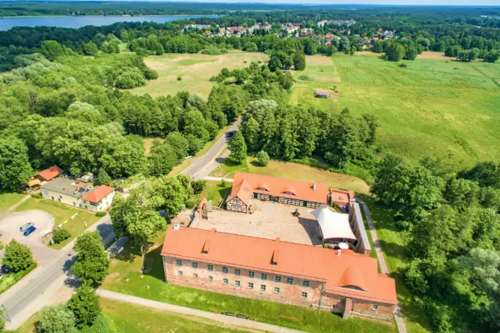 Visit Storkow Castle A large building surrounded by trees.