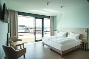 Disabled-friendly room A bedroom with a bed and chairs.