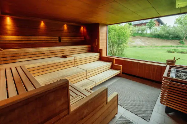 Wooden sauna with a window and grass in the foreground