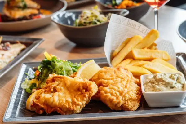 Fish and Chips Ein Teller mit Essen auf einem Tisch.