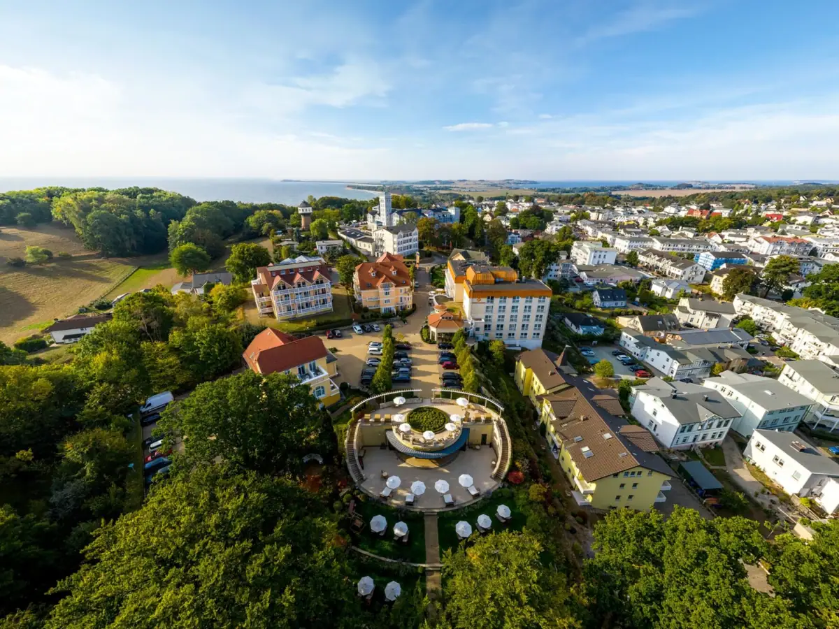 aja Nordperd & Villas Göhren Aerial view of a hotel with several houses with trees and the sea in the background.