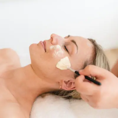 Facial treatment A woman lies on her back with a brush on her face during an application.