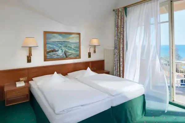 Ein Hotelzimmer mit zwei Betten und einem Fenster.