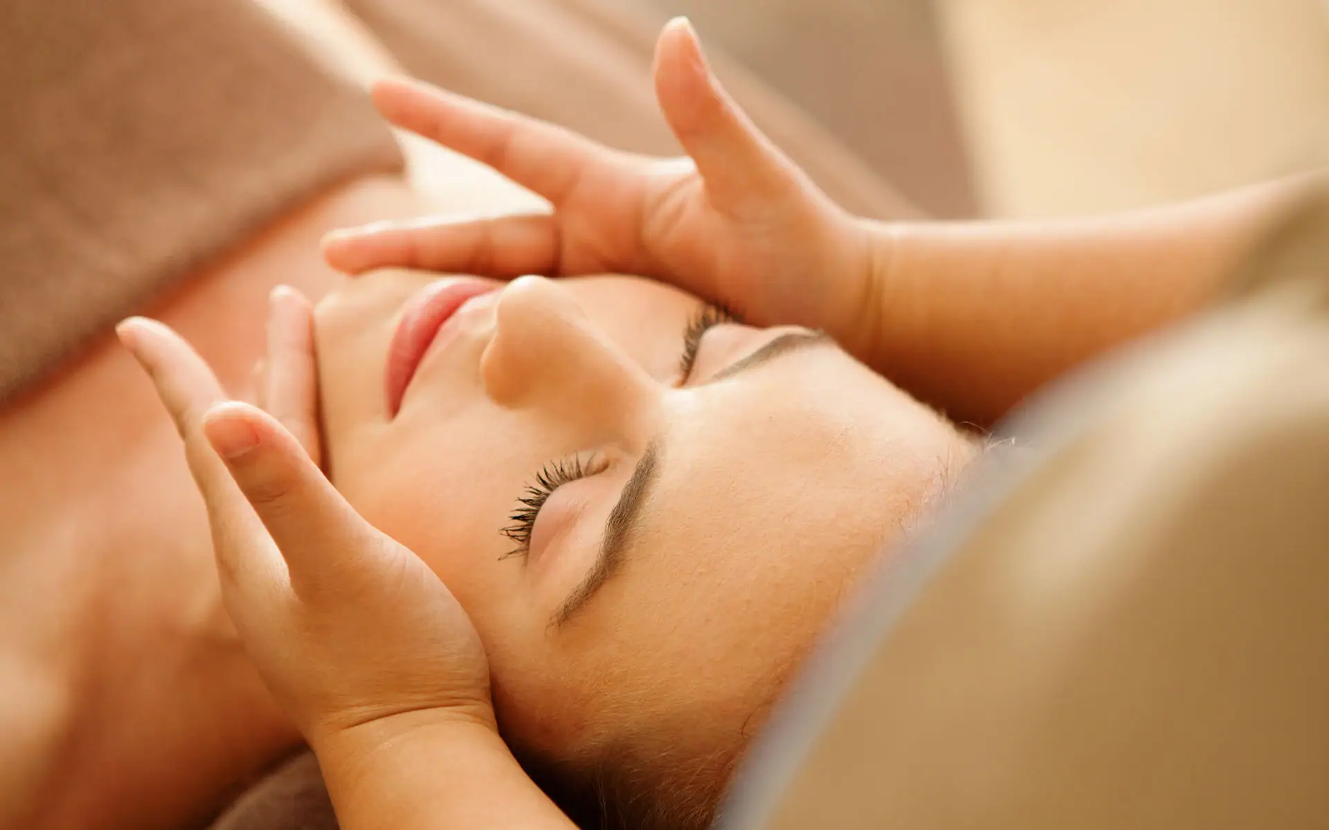 A woman lying down with her eyes closed, appearing relaxed and comfortable.