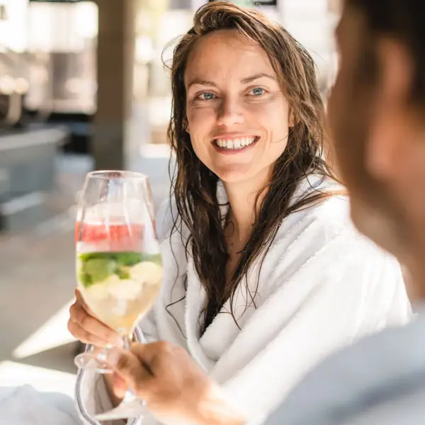 Drinks in a bathrobe A woman in a white bathrobe holds a wine glass.