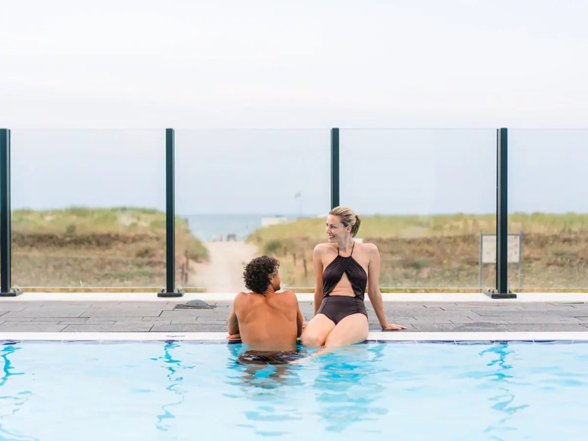 Outdoor pool at the aja Warnemünde A man and a woman are sitting in a swimming pool.