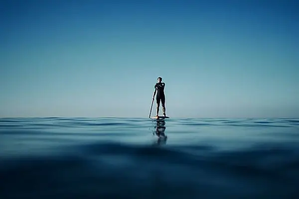 A person on a paddleboard in the ocean.